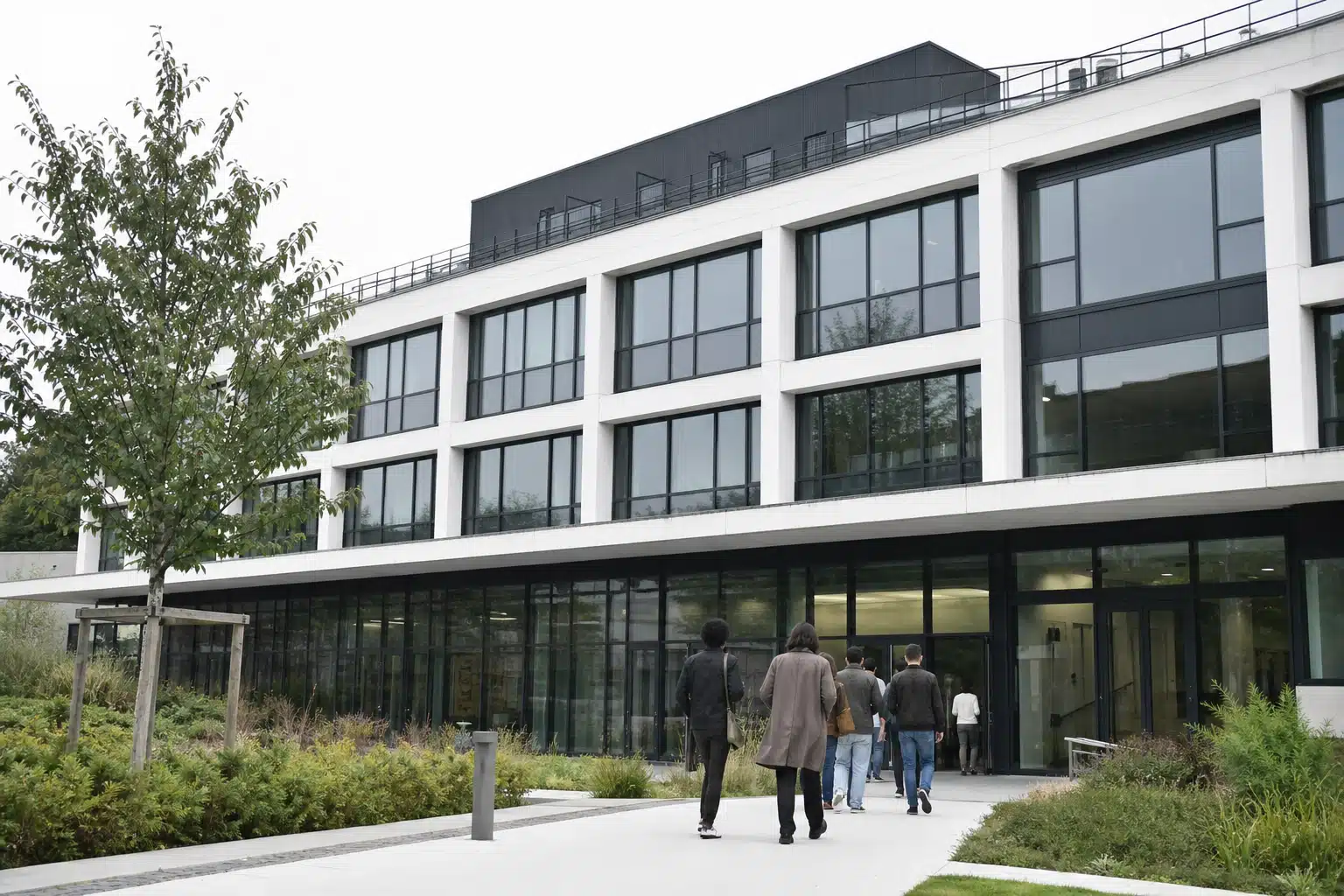 Groupe marchant vers bâtiment de bureaux à façade vitrée