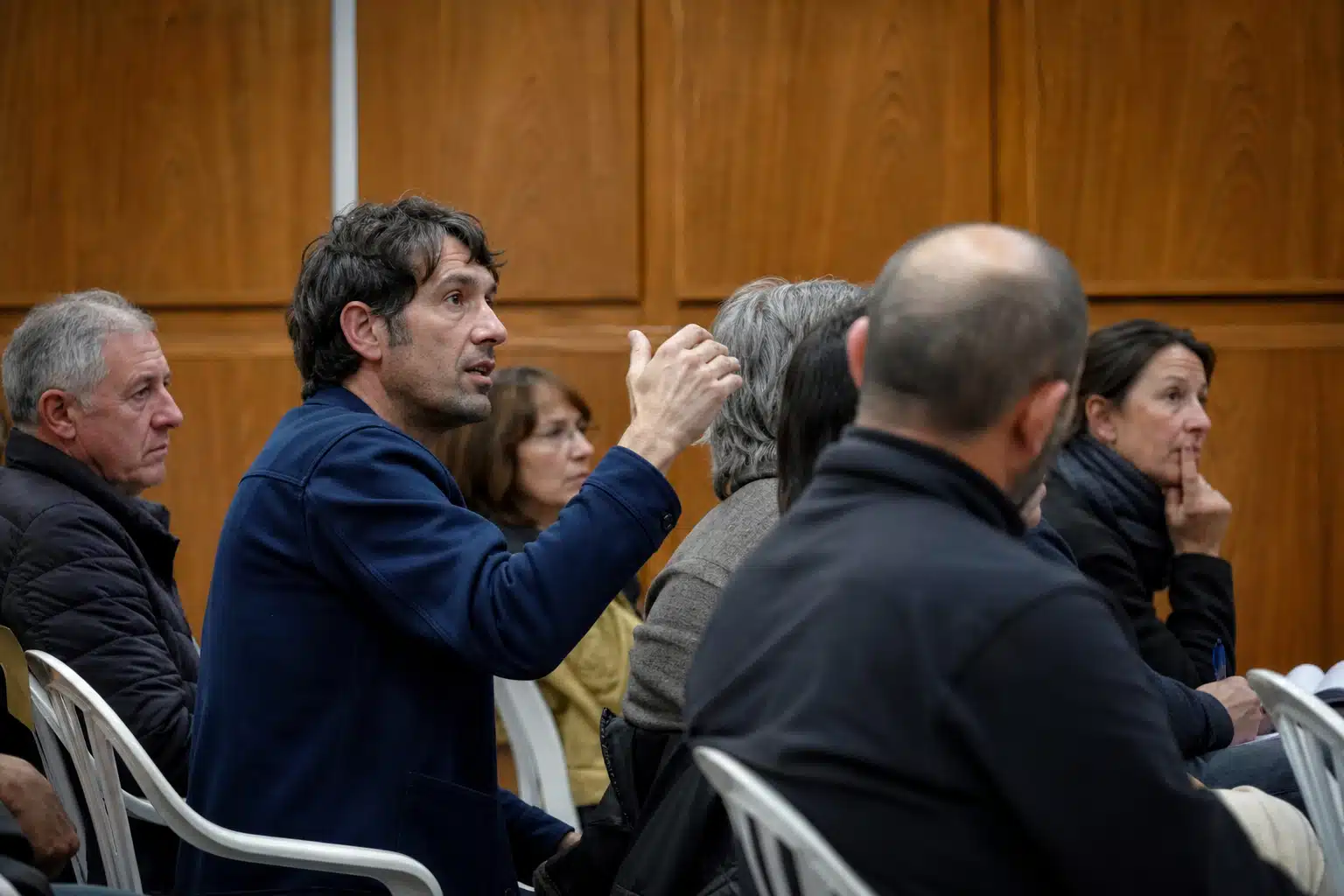 Homme en veste bleue prenant la parole